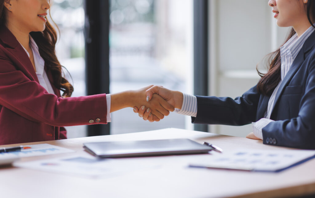 Businesswomen shaking hands finalizing agreement in office