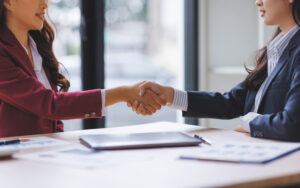 Businesswomen shaking hands finalizing agreement in office